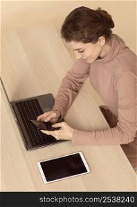 high view woman sitting various digital devices