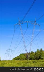 High-voltage line of electricity transmissions on field , among wood