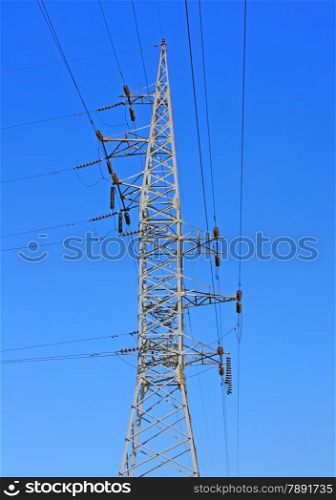 high voltage post against the blue sky