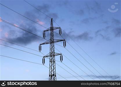 High voltage post or high voltage tower against the evening cloudy sky