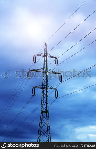 High voltage post or high voltage tower against the evening cloudy sky