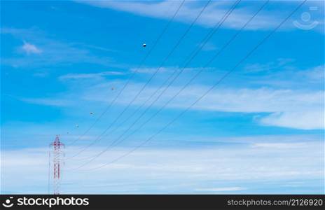 High voltage power lines against blue sky. High voltage electric transmission tower. Electricity pylon and electric power transmission lines. High Voltage tower provide power supply. Power and energy.
