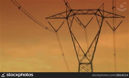 high voltage pylons at sunset. 30 fps