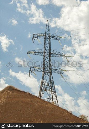 high voltage tower against the blue sky with clouds. post electric, insulated