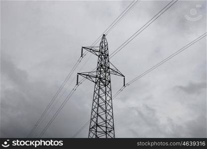 High-voltage tower on a grey sky of background.
