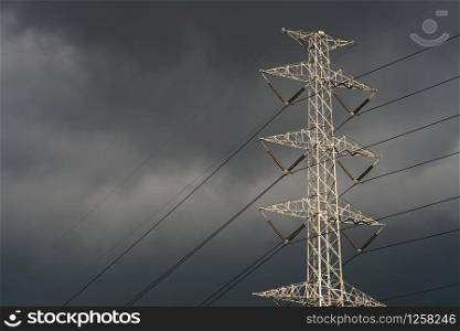 High voltage tower with electric cable and dark sky