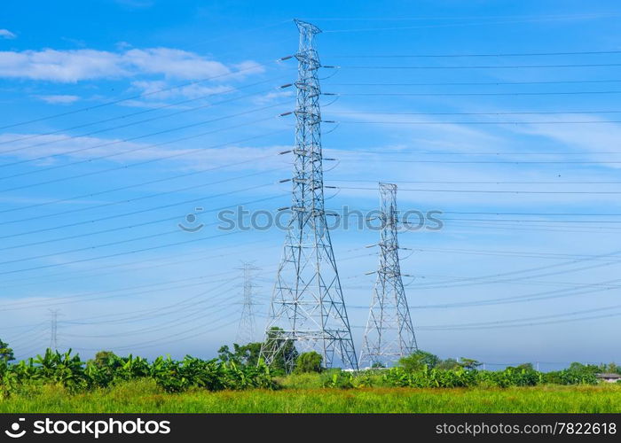 High voltage towers. The meadow below. Industry and nature coexist in appropriate Slightly cloudy sky.