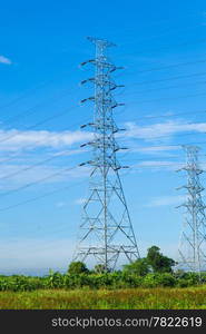 High voltage towers. The meadow below. Industry and nature coexist in appropriate Slightly cloudy sky.