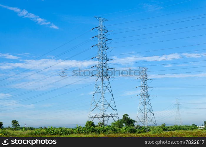 High voltage towers. The meadow below. Industry and nature coexist in appropriate Slightly cloudy sky.