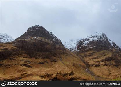 Highland&rsquo;s snowy hills in the rain in Glencoe, Scotland