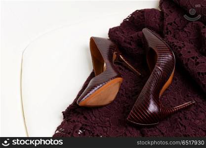 Hight heel shoes for Christmas party. Hight heel elegant shoes and laced dress in chair close up