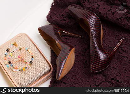 Hight heel shoes for Christmas party. Pair of High heel elegant shoes, golden bag and laced dress
