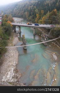 Highway and pedestrian suspension bridge across mountain river (view from above, Jaremche, Ivano-Frankivsk Region, Ukraine) Three shots composite picture.