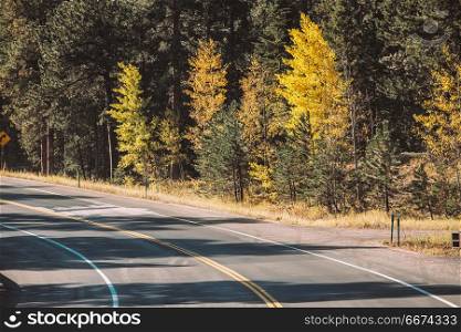 Highway at autumn in Colorado, USA. . Season changing from autumn to winter. Highway in Colorado, USA.