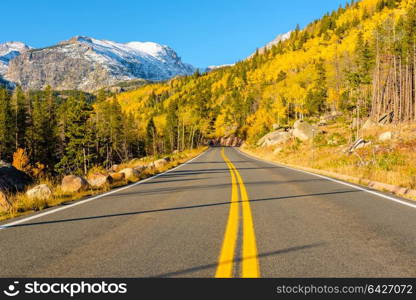 Highway at autumn sunny day in Rocky Mountain National Park. Colorado, USA.