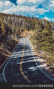 Highway at autumn sunny day in Rocky Mountain National Park. Colorado, USA.