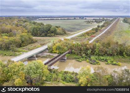 highway bridge and trestle of abandoned railway across Cache River in Illinois above confluence with the Mississippi River, aerial view of fall scenery