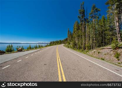 Highway by the lake in Yellowstone . Highway by the lake in Yellowstone National Park, Wyoming, USA
