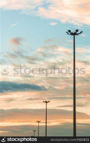 Highway light pole against the blue sky and clouds at sunset.