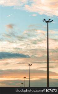 Highway light pole against the blue sky and clouds at sunset.