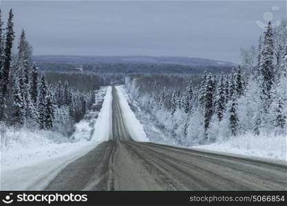 Highway passing through snow covered forest, Alaska Highway, Northern Rockies Regional Municipality, British Columbia, Canada