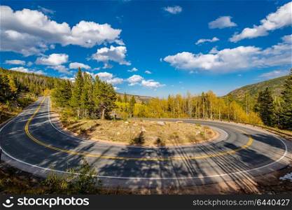 Highway with hairpin turn (switchback) at autumn sunny day in Rocky Mountain National Park. Colorado, USA.