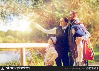 hike, travel, tourism and people concept - happy family walking with backpacks in woods. happy family with backpacks hiking