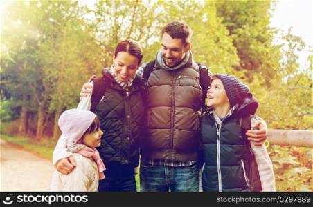 hike, travel, tourism and people concept - happy family with backpacks in woods. happy family with backpacks hiking
