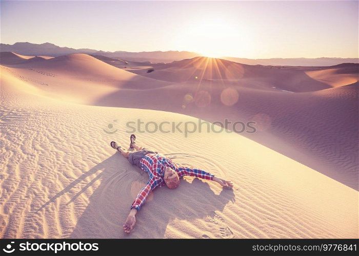 Hiker among sand dunes in the desert