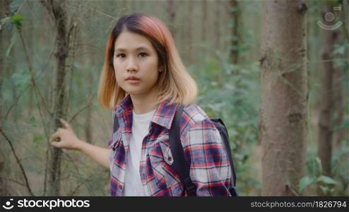 Hiker Asian backpacker woman on hiking adventure feeling freedom walking in forest, Female enjoy her holidays near lots of tree. Lifestyle women travel and relax in freetime concept.