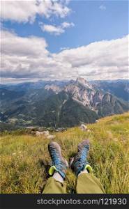 Hiker boots. Rambler having fun and enjoying wonderful breathtaking mountain view. Freedom concept. Italian Alps. Friuli Venezia Giulia.  Concept of adventure.