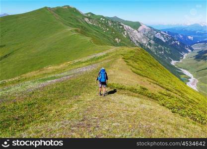 Hiker going along green hills in Caucasus mountains, Svaneti,Georgia. Summer season.