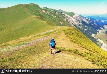 Hiker going along green hills in Caucasus mountains, Svaneti,Georgia. Summer season.