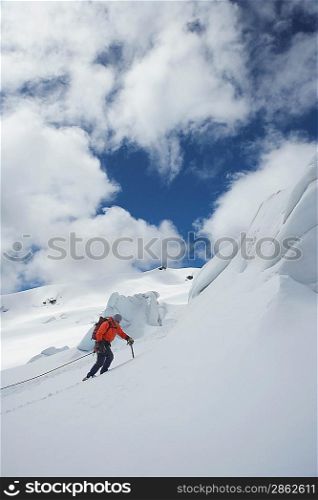 Hiker going up snowy mountain slope