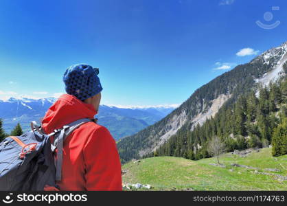 hiker looking up mountain during trip under beautiful blue sky