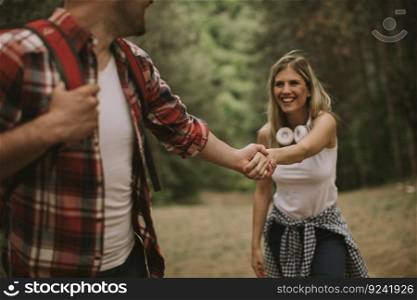 Hiker man holding womans hand and leading her on nature outdoor