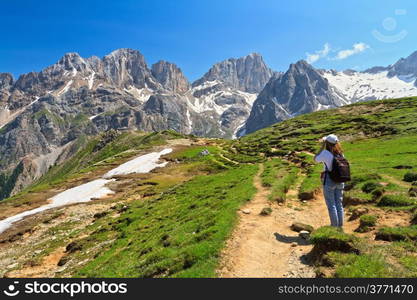 hiker on footpath in Contrin Valley, Trentino, Italy. On background mount Marmolada