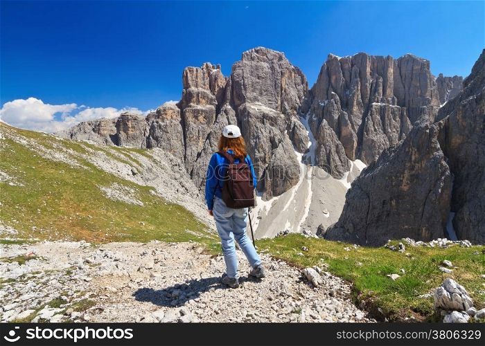 hiker on footpath in Sella mountain, on background Mezdi valley and Piz da Lech peak, south Tyrol, Italy