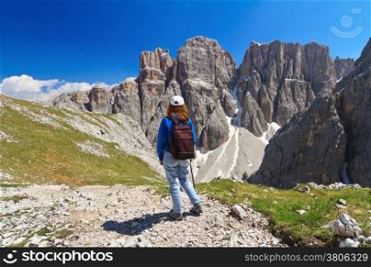 hiker on footpath in Sella mountain, on background Mezdi valley and Piz da Lech peak, south Tyrol, Italy