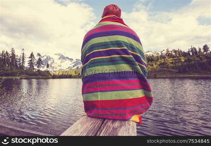 Hiker relaxing at serene mountain lake