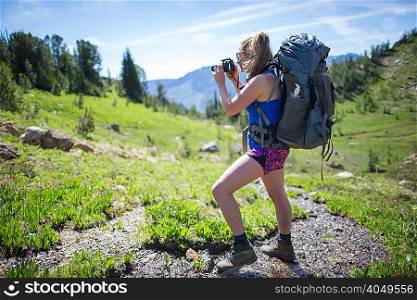Hiker taking photograph of view, Enchantments, Alpine Lakes Wilderness, Washington, USA