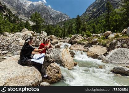 Hiker trekkers discussing route on trek in Himalayas mountains. Himachal Pradesh,India