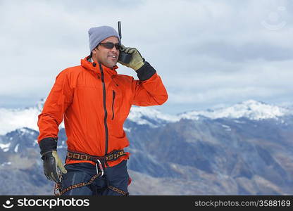 Hiker using walkie-talkie on mountain peak