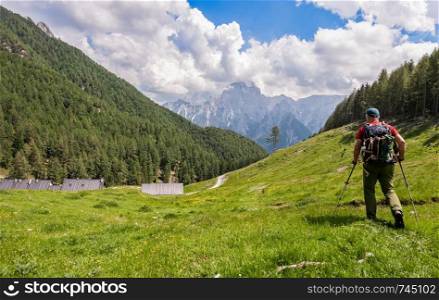 Hiker walk on trail and admiring the panorama. Italy Alps.
