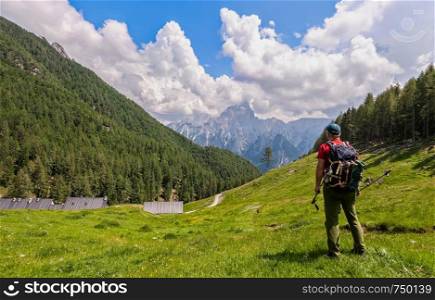 Hiker walk on trail and admiring the panorama. Italy Alps.