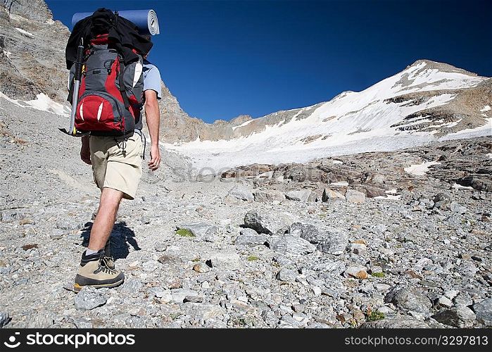 Hiker walks on a mountain path, Gran Paradiso Park, Italy