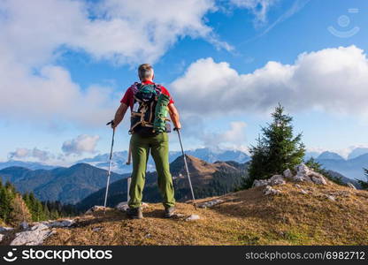 Hiker with backpack is stand on mountain top.