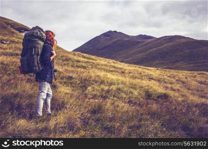 Hiker with backpack walking in the mountains