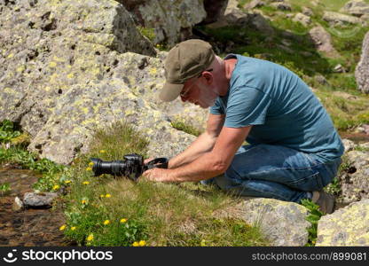 Hiker with camera taking picture of a small stream