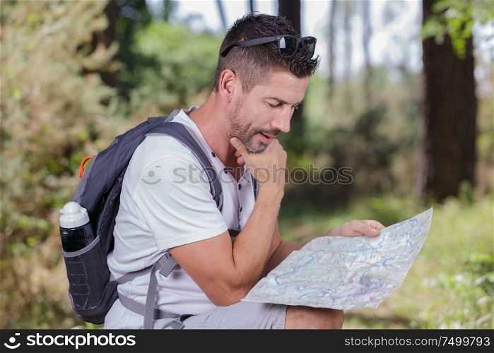 hiker with map exploring wilderness on trekking adventure